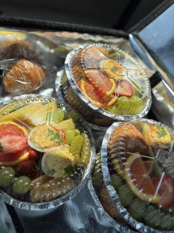Individual brunch boxes with fresh fruit, eggs and pastries
