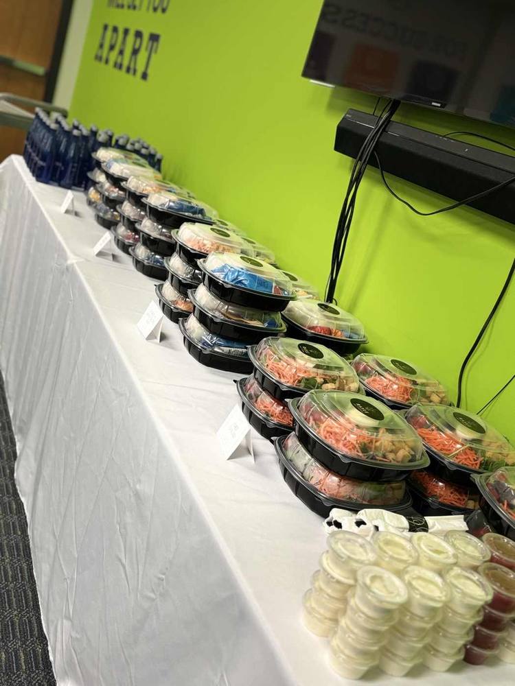 Rows of individually packaged chef salads with dressings and bottled water