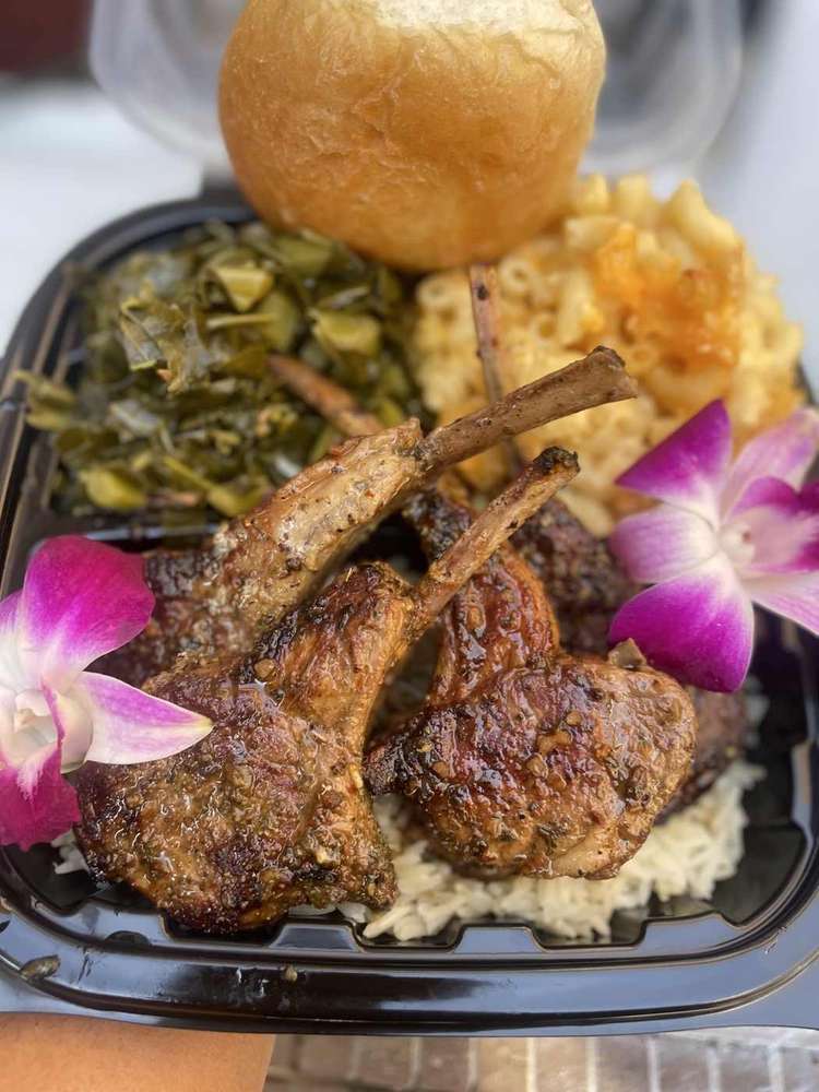 Glazed lamb chops served with rice, greens, macaroni and cheese and a dinner roll
