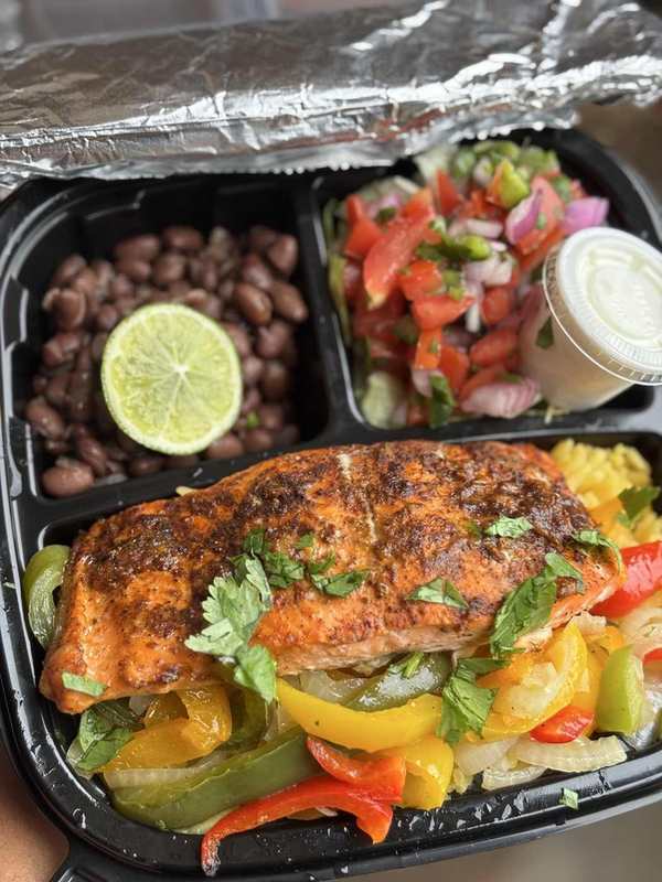 Seasoned salmon over peppers with black beans, fresh salsa and sauce
