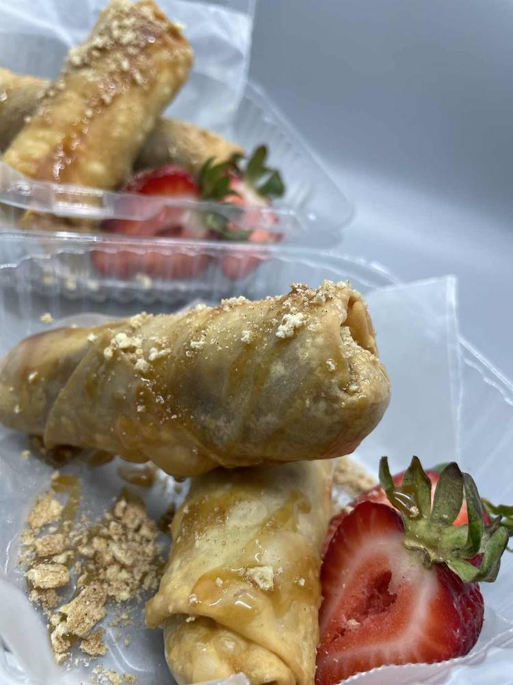 Sweet potato egg rolls plated with strawberries