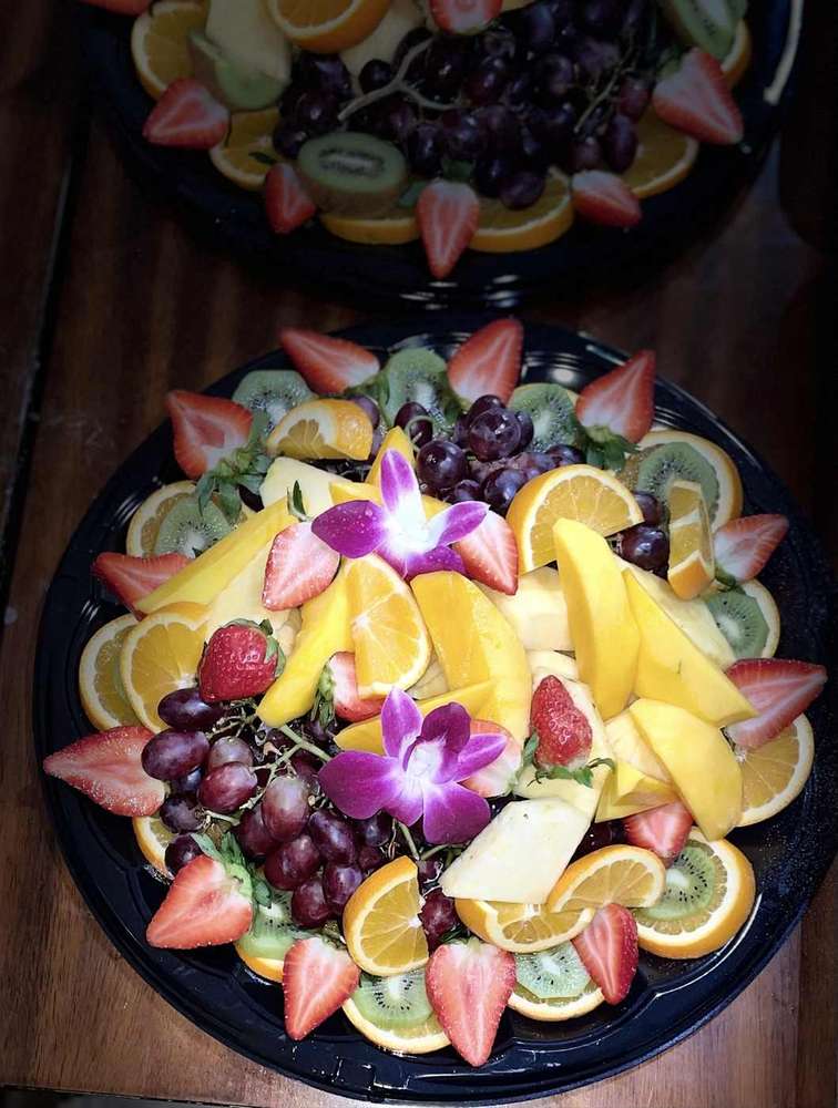 Tropical fruit platter with mango, pineapple, kiwi, oranges, grapes and strawberries